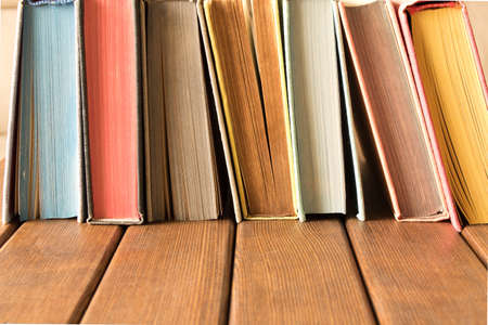 Stack of books on a wooden table. The concept of education and knowledge from books. Close upの写真素材