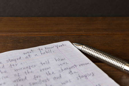 Pen and notebook in English at the school Desk. The concept of education.