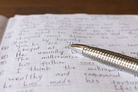 Pen and notebook in English at the school Desk. The concept of education.