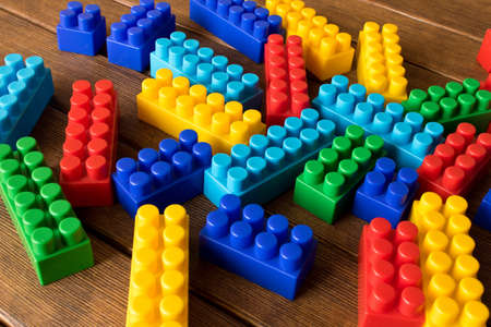 Colorful children's plastic constructor on a wooden table. Conceptual approach to the development of...