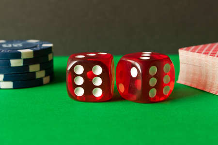 Dice, poker chips and playing cards on the green table . Game concept. Games of chance.