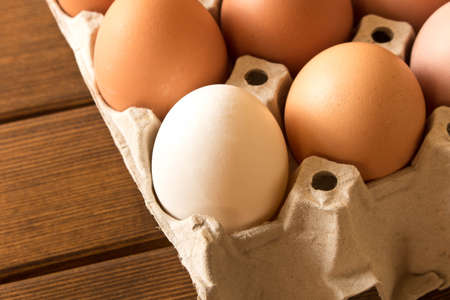 Eggs in a cardboard box on a wooden table. Close up. Macro.