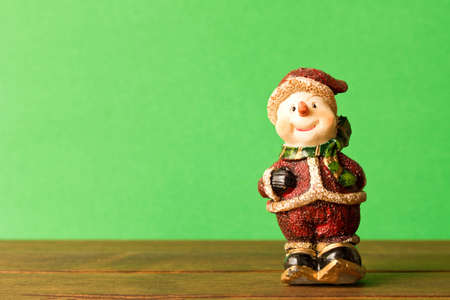 Funny Christmas snowman on green background. With empty text space. The concept of Christmas.