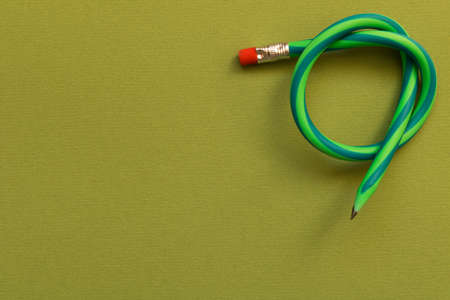 Flexible pencil . Isolated on dark green background.