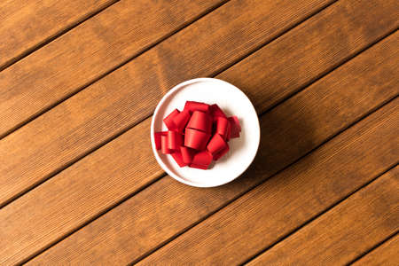 A small gift on a wooden table. The view from the top . The concept of a gift made with your own hands.の写真素材