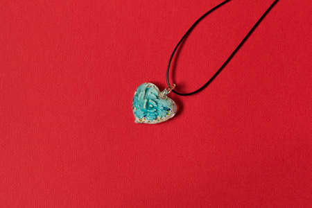 Beautiful glass heart . Isolated on red background. The concept of holiday gift.の写真素材