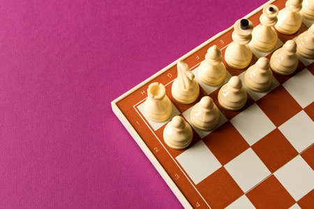 Board with white chess on purple background.  The concept of the game of chess.