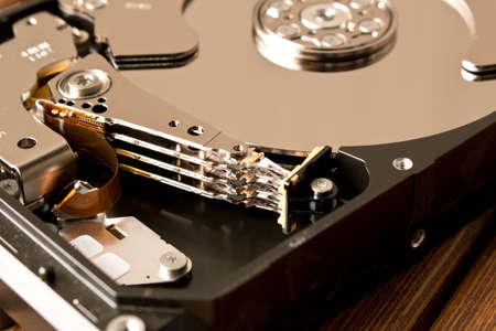 Disassembled hard drive on wooden table . Close up.