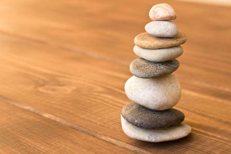 Balance the stones on the wooden table