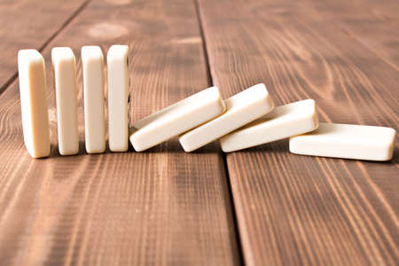 Playing dominoes on a wooden table. Domino effect.の写真素材