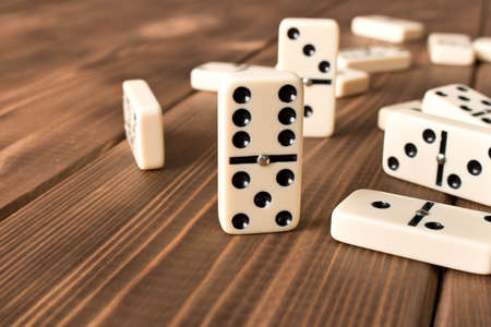 Playing dominoes on a wooden table. Domino effect.の写真素材