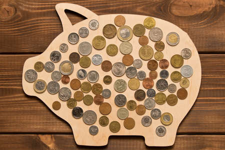 Many different coins on wooden pig. The concept of saving moneyの写真素材