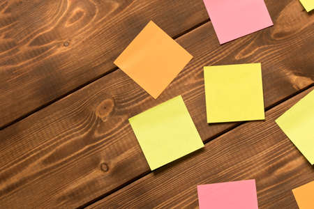 Different colored stickers on a wooden background.