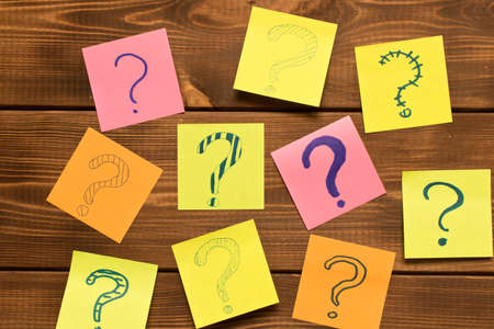 Different colored stickers with questions on wooden background. Concept of idea development.の写真素材