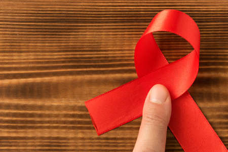 Red aids ribbon.  Isolated on wooden background with empty space for text.