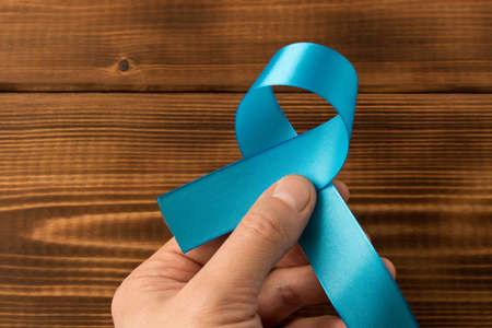 Blue ribbon.  Isolated on wooden background with empty space for text. Close upの写真素材