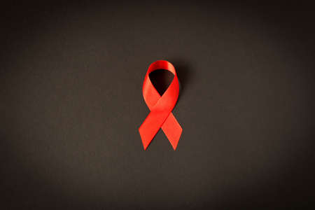 Red aids ribbon.  Isolated on black background with empty space for textの写真素材