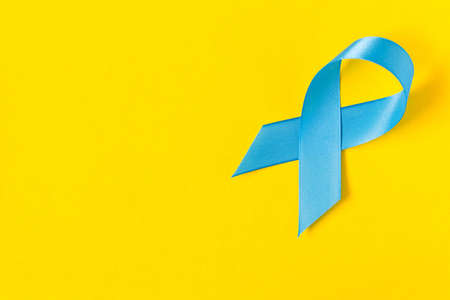 Blue ribbon.  Isolated on yellow background with empty space for text. Close upの写真素材