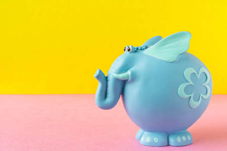 Funny blue toy elephant. On a yellow-pink backgroundの写真素材