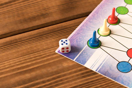Multi-colored game chips with dice on the playing board. Board game conceptの写真素材