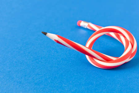 Flexible pencil . Isolated on blue background. Bending pencilの写真素材