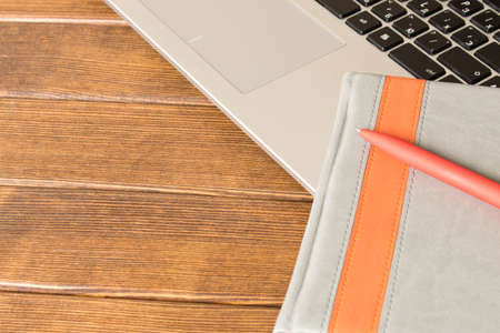 Notebook with pen and notebook on wooden table. E-learning concept.の写真素材