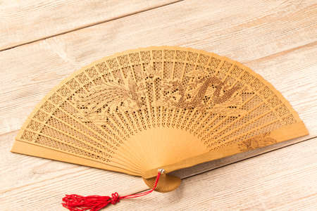Beautiful wooden fan on wooden tableの写真素材
