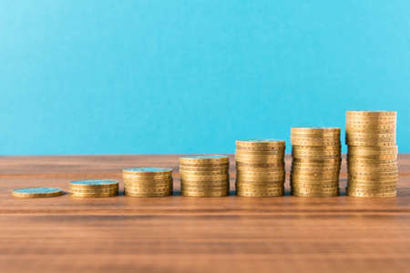 Stacks of coins on a wooden table. Business concept and growth of capital