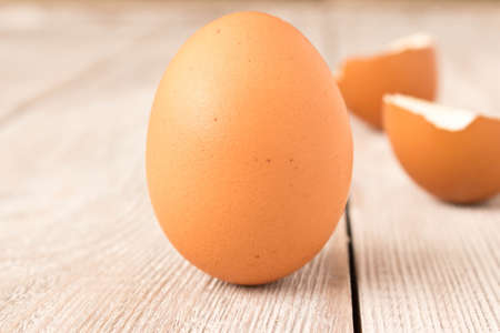 Chicken egg and eggshell on wooden table. Selective focusの写真素材