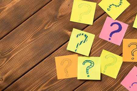 Different colored stickers with questions on wooden background. Concept of idea development.の写真素材