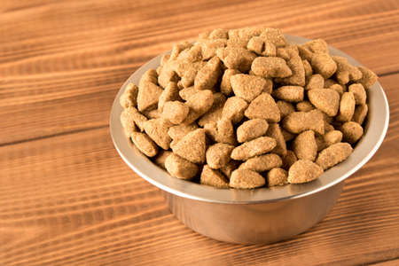 Bowl with dog food on a wooden table. Close upの写真素材