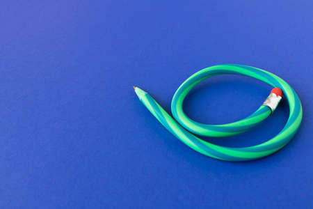 Flexible pencil. Isolated on blue background. Bending pencilの写真素材