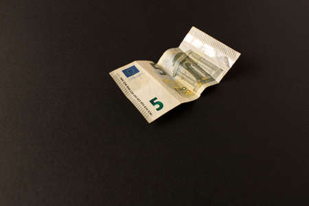 5 Euro banknote on a dark background. Close up. The concept of savings