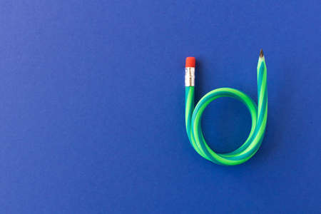 Flexible pencil. Isolated on blue background. Bending pencilの写真素材
