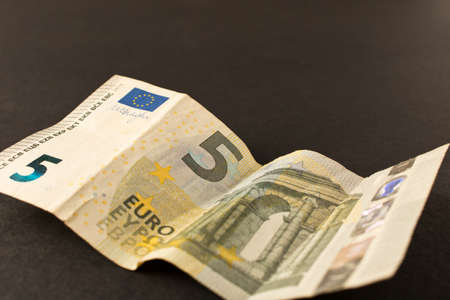 5 Euro banknote on a dark background. Close up. The concept of savings