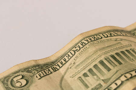 Old 5 dollar bill on a white background . Close up. The concept of saving moneyの写真素材