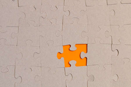 Jigsaw puzzles on orange background. The concept of development of thinkingの写真素材