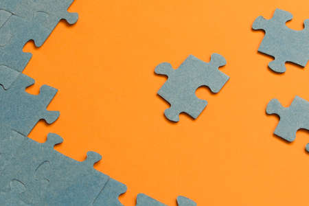 Abstract background of many puzzles on an orange background. The concept of teamworkの写真素材