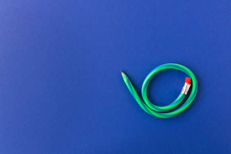 Flexible pencil. Isolated on blue background. Bending pencil