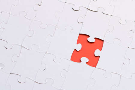 White jigsaw puzzles on red background. The concept of development of thinking. The concept of...