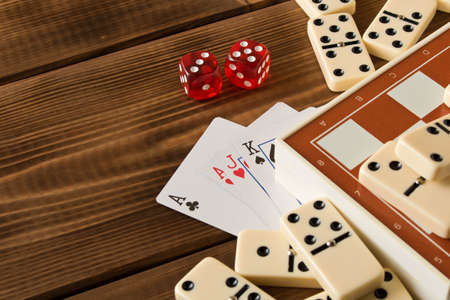 Chess, playing cards, dominoes on a wooden table. The concept of Board games