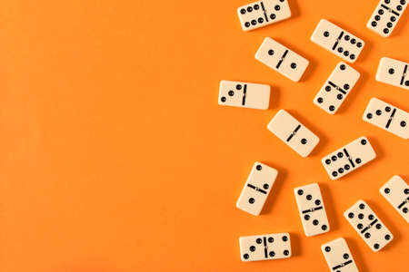 Playing dominoes on a orange table. Domino effectの写真素材