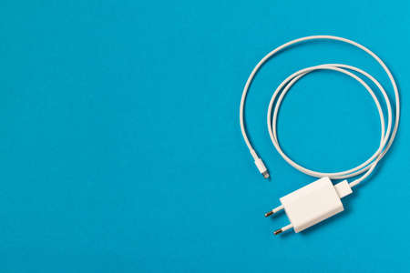 Charger on blue background. Close up. Empty text space