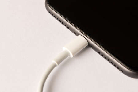 Smartphone on charge. On white background. Close up