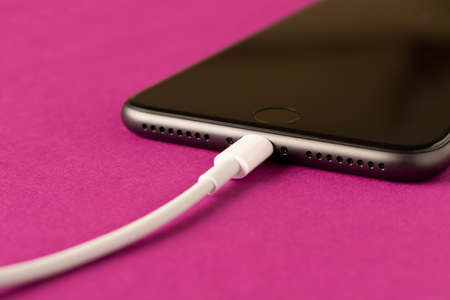 Smartphone on charge. On a purple background. Close upの写真素材