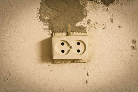 Electrical outlet on the old concrete wall. Isolated on light backgroundの写真素材