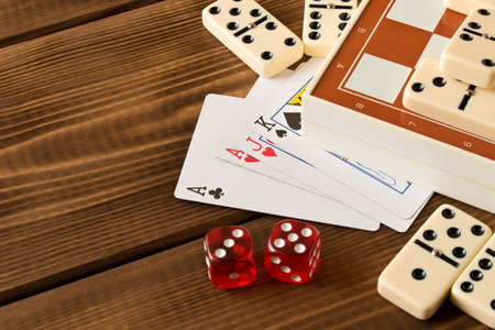 Chess, playing cards, dominoes on a wooden table. The concept of Board gamesの写真素材
