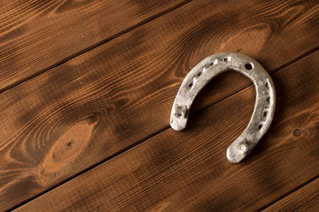 Silver horseshoe on a wooden table. An old horseshoeの写真素材