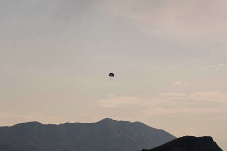 Skydiver flying far in the sky over the mountains
