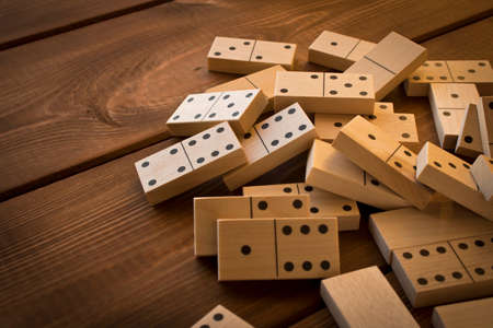 Playing dominoes on a wooden table. Leisure games concept. Domino effect.の写真素材